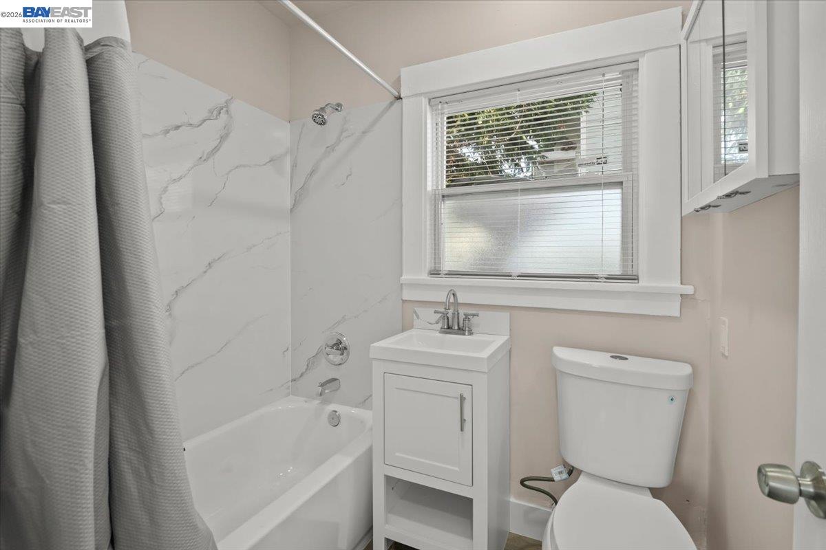 1504 Tenth Street Berkeley, CA 94710 - Photo 9 of 12 a bathroom with a toilet sink and mirror with bathtub
