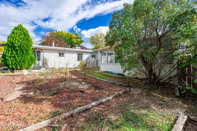 a view of a house with a yard and potted plants