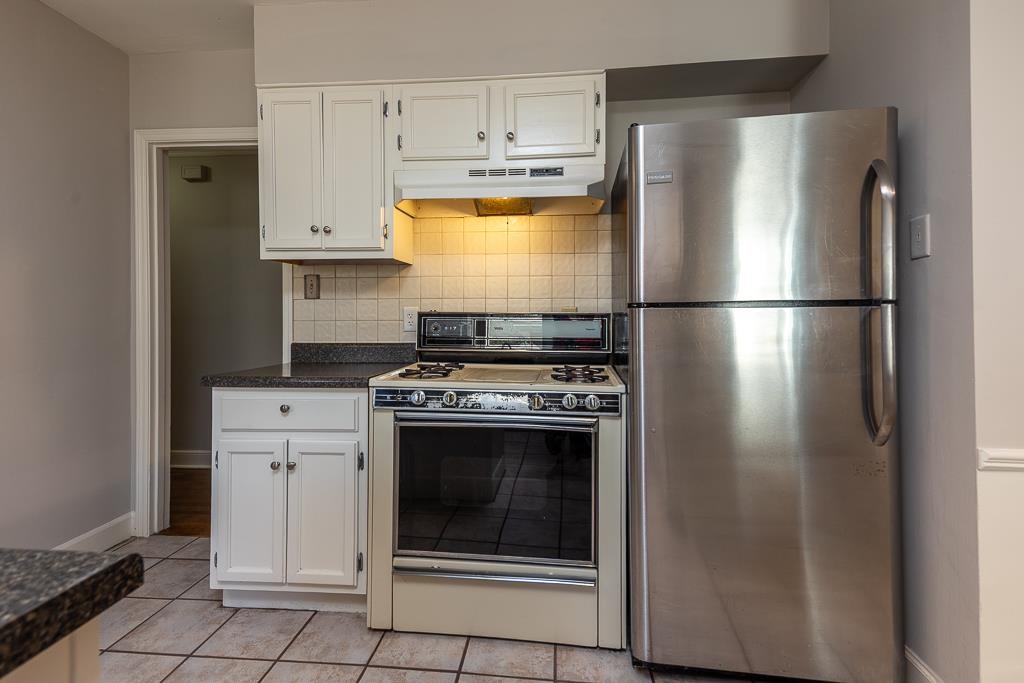 500 Colonial Road Memphis, TN 38117 - Photo 12 of 35 a kitchen with refrigerator a stove and white cabinets