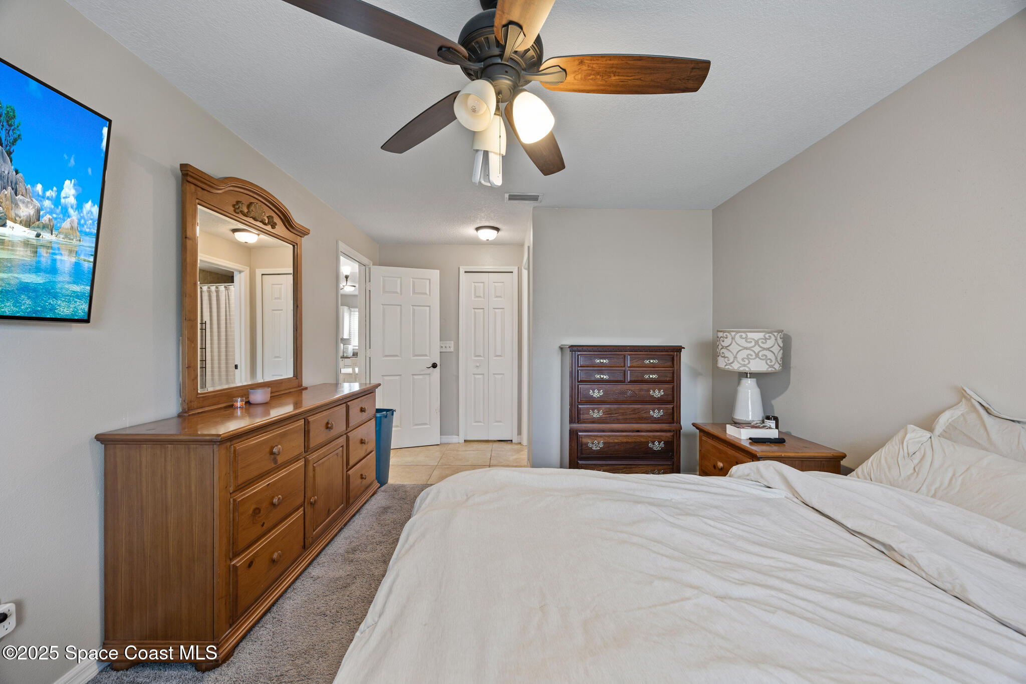1666 Owl Lane Melbourne, FL 32935 - Photo 15 of 19 a bedroom with a bed and a chandelier