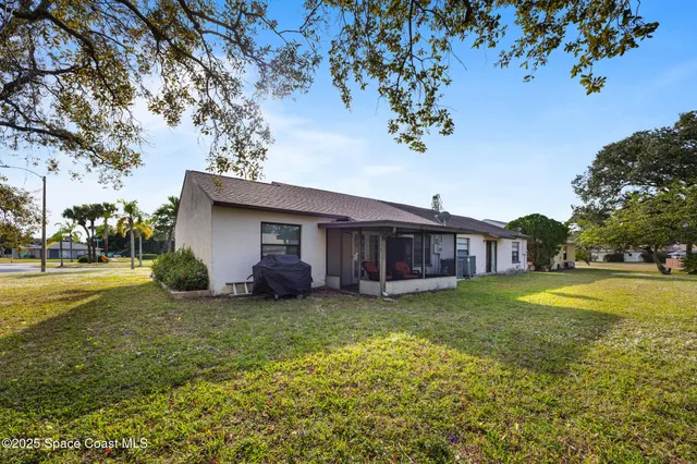 a view of a house with a big yard and large trees