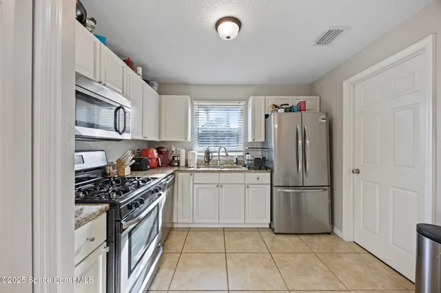 a kitchen with stainless steel appliances a refrigerator sink and cabinets