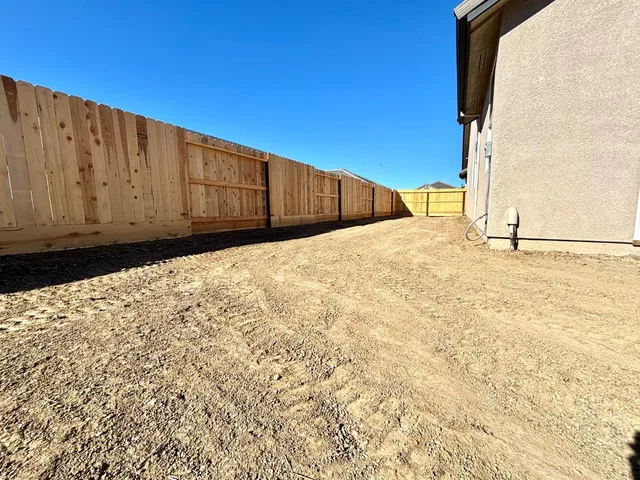 a view of a backyard with wooden fence