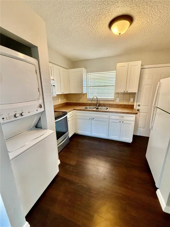8124 Cormel Street, Unit 8126 Port Richey, FL 34668 - Photo 8 of 13 a kitchen with granite countertop white cabinets and white appliances