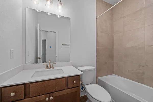 a bathroom with a sink toilet vanity and shower