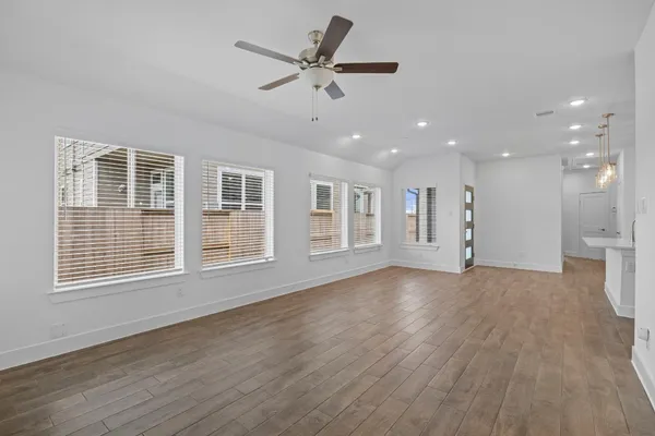 a view of an empty room with a window and wooden floor