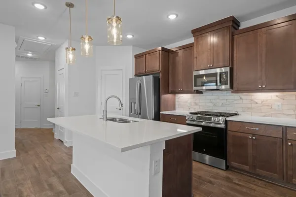 a kitchen with stainless steel appliances granite countertop a sink stove and refrigerator