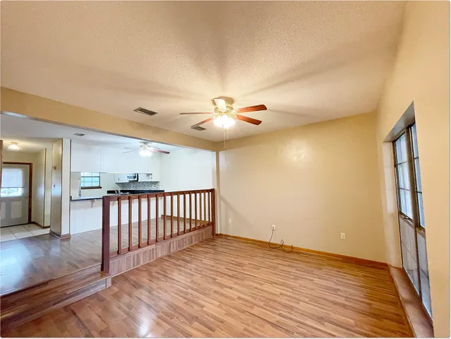 a view of a livingroom with a ceiling fan and wooden floor