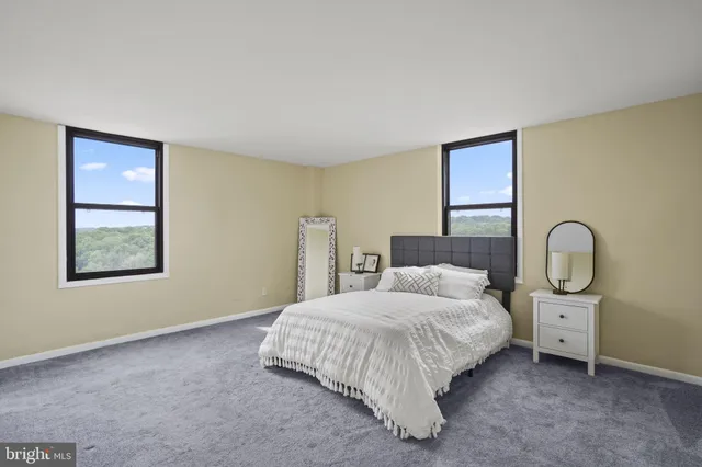 a bedroom with a bed a mirror and a window