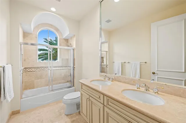 a bathroom with a granite countertop sink a toilet and shower