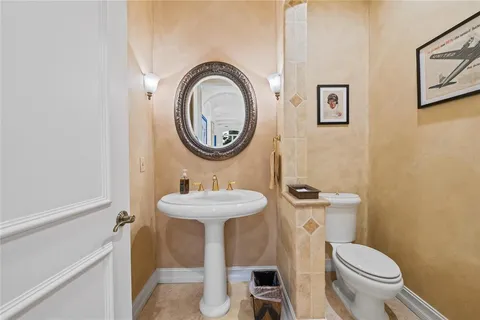 a bathroom with a toilet sink and mirror