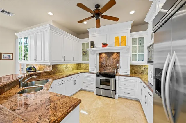 a kitchen with stainless steel appliances granite countertop a sink a stove and a refrigerator