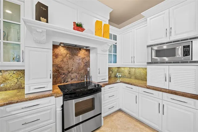 a kitchen with granite countertop cabinets stainless steel appliances and a window