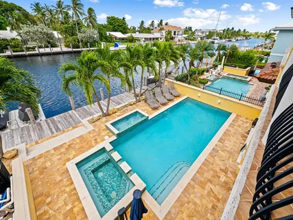 a view of a swimming pool with outdoor seating and plants