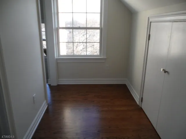 a view of a room with wooden floor and a window