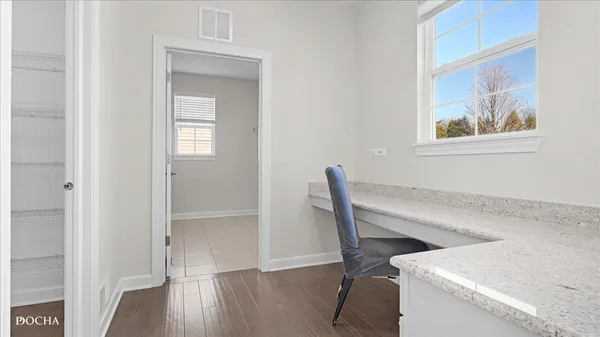 a view of a workspace with furniture and wooden floor