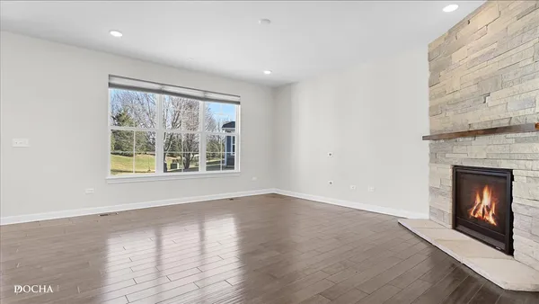 a view of an empty room with a fireplace and a window