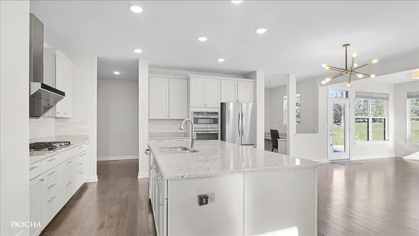 a kitchen with stainless steel appliances kitchen island granite countertop a refrigerator and a stove top oven