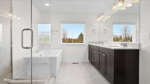 a bathroom with a double vanity sink a mirror and a shower