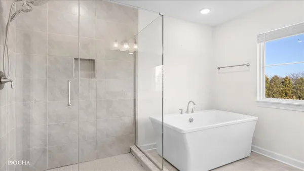a white bath tub sitting next to a white sink and vanity