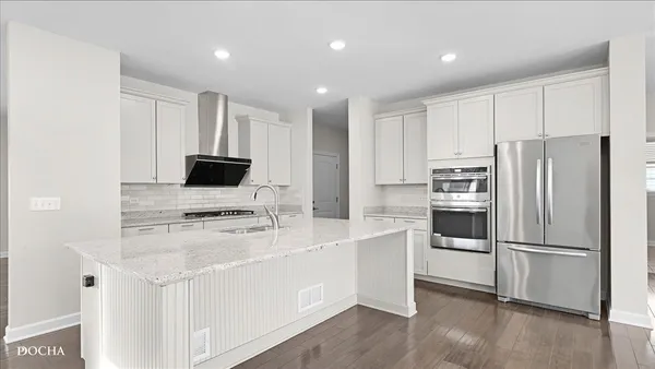 a kitchen with appliances a sink and a refrigerator
