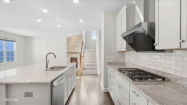 a kitchen with a sink stove top oven and cabinets