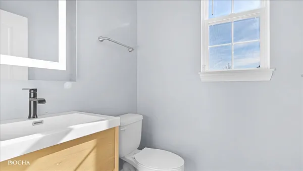 a bathroom with a sink a toilet and a mirror