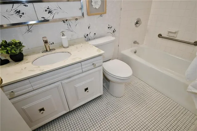 a bathroom with a granite countertop sink mirror vanity and toilet