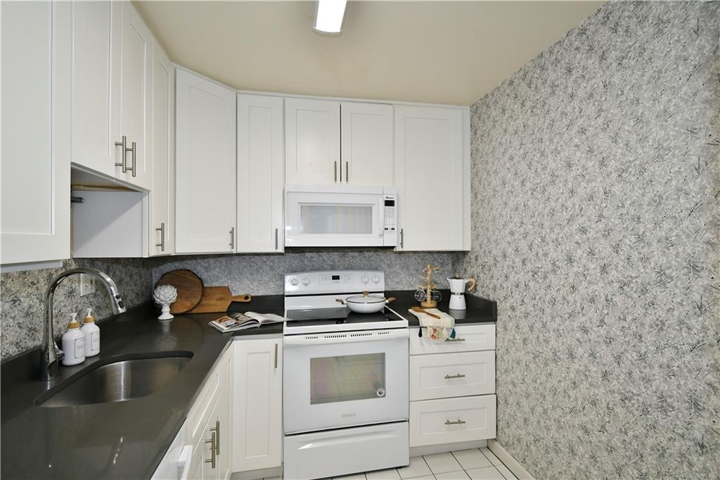 425 North Neville Street, Unit 204 Pittsburgh, PA 15213 - Photo 8 of 38 a kitchen with granite countertop white cabinets and white appliances