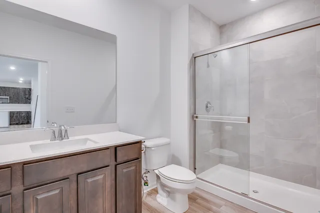 a bathroom with a sink a toilet and shower