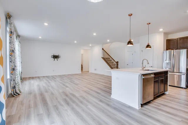 a kitchen with stainless steel appliances granite countertop a sink a stove and a wooden floor