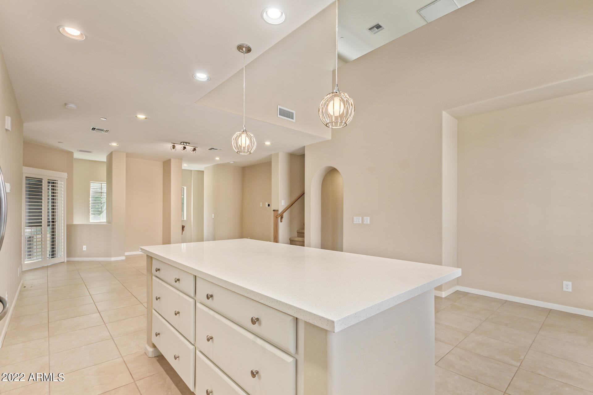 3935 East Rough Rider Road, Unit 1369 Phoenix, AZ 85050 - Photo 16 of 44 a large white kitchen with a large island oven a sink dishwasher and a refrigerator with wooden floor