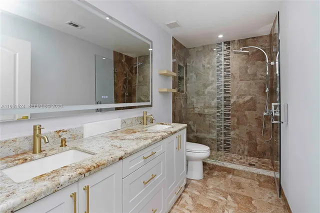 a bathroom with a granite countertop sink and a mirror