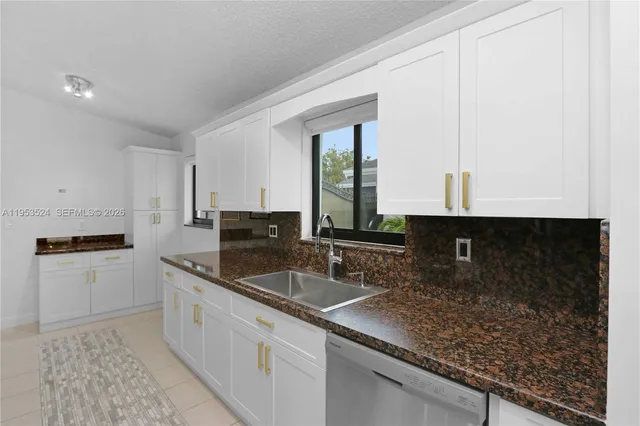 a large kitchen with a granite countertop refrigerator a sink and dishwasher