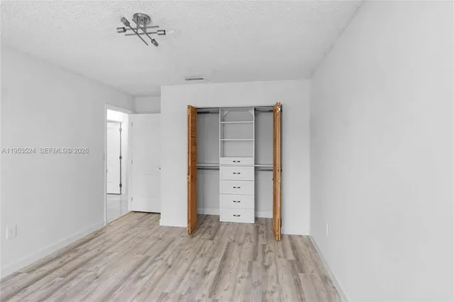 an empty room with a ceiling fan and window