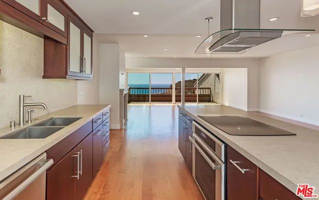 a kitchen with kitchen island a sink and wooden cabinets