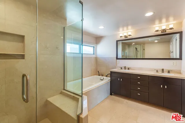 a bathroom with a tub sink shower and mirror