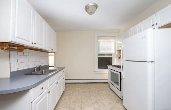 a kitchen with a refrigerator sink and cabinets
