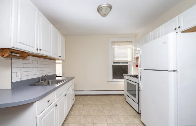 a kitchen with a refrigerator sink and cabinets