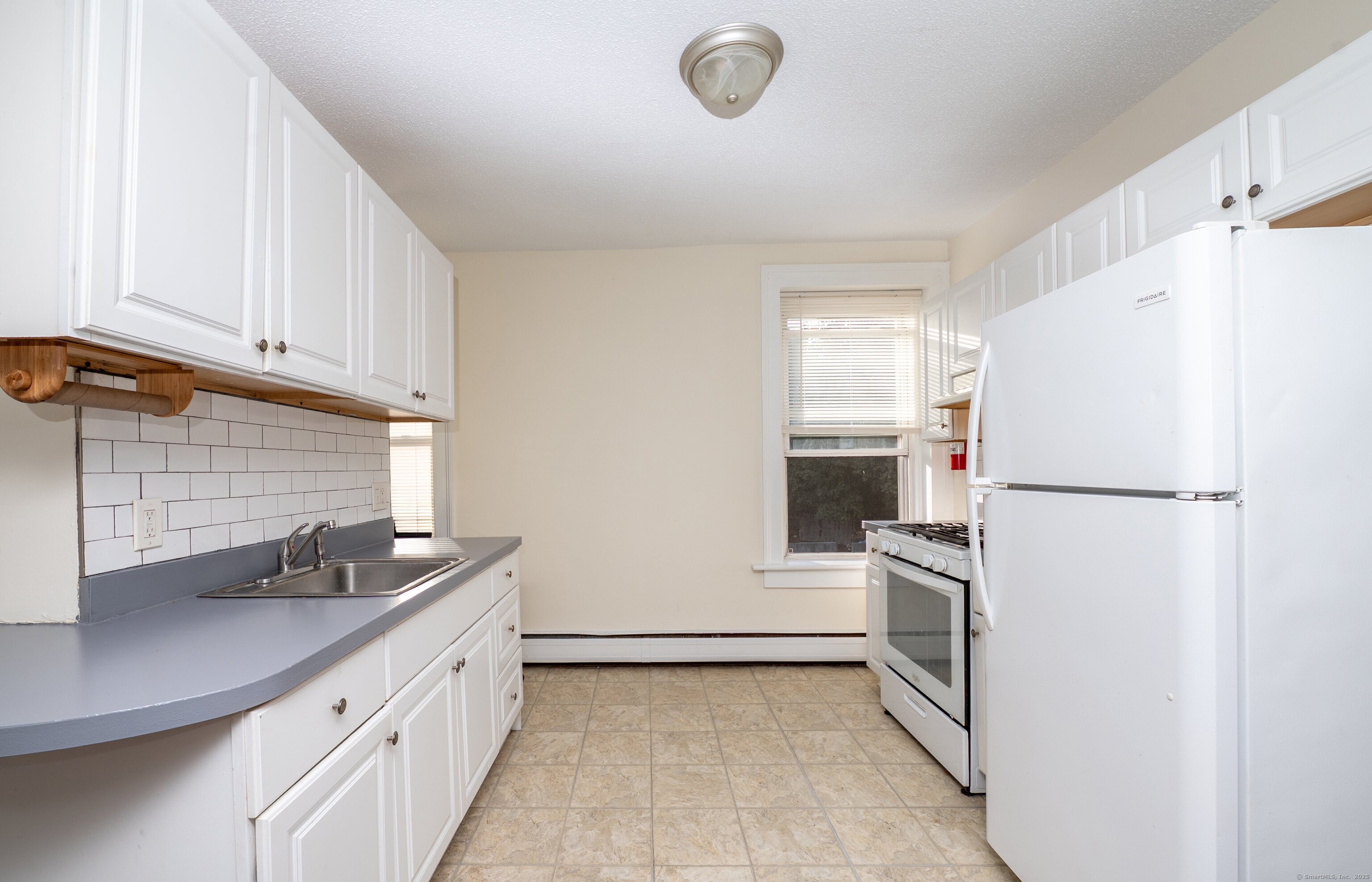 a kitchen with a refrigerator sink and cabinets
