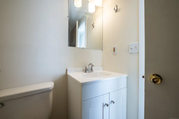 a bathroom with a sink a toilet and a mirror