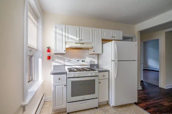 a kitchen with a stove top oven and refrigerator