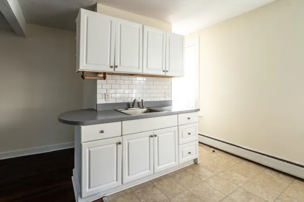 a kitchen with granite countertop white cabinets and sink