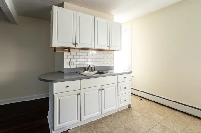 a kitchen with granite countertop white cabinets and sink