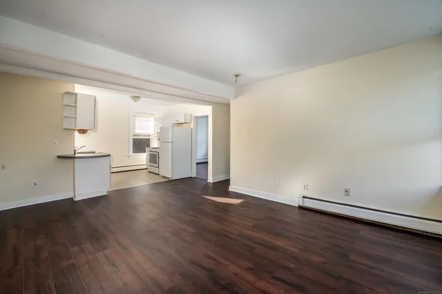 an empty room with wooden floor and white walls