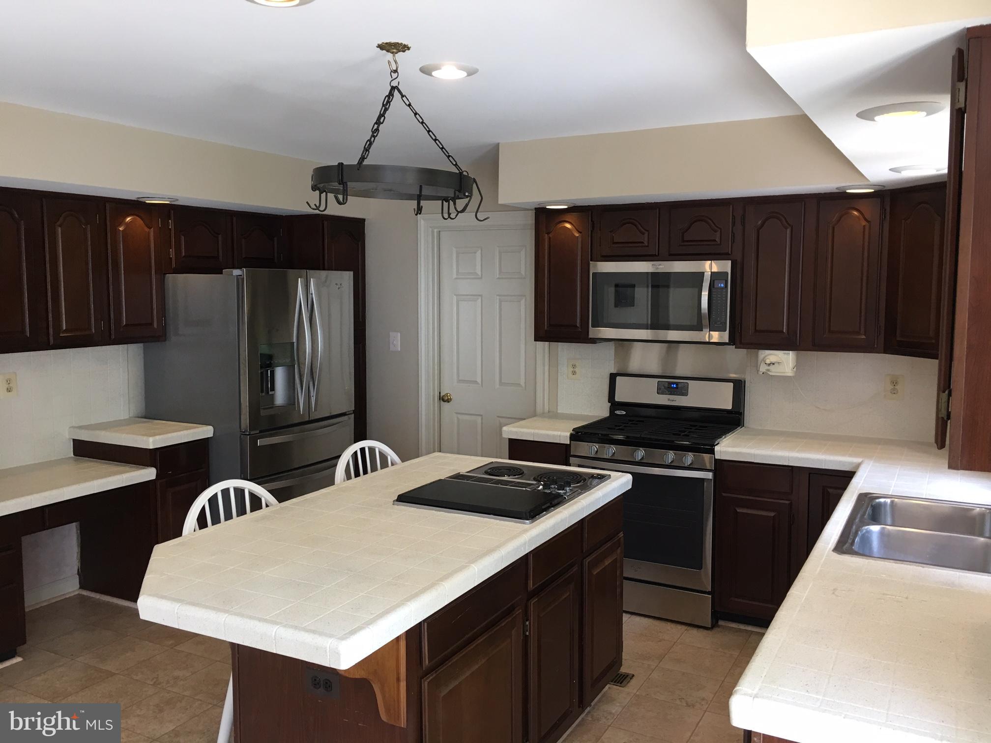 17106 Campbell Farm Road Poolesville, MD 20837 - Photo 15 of 30 a kitchen with stainless steel appliances a stove a sink island and a refrigerator