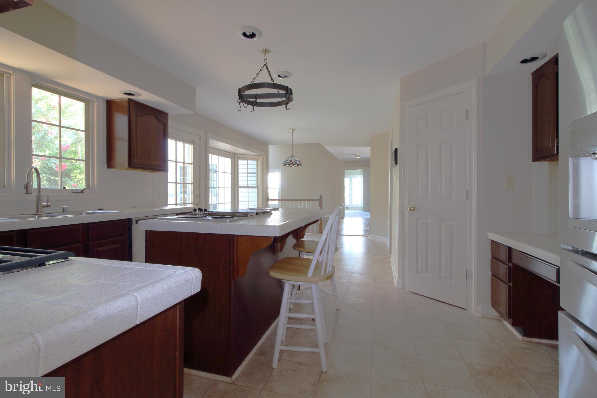 17106 Campbell Farm Road Poolesville, MD 20837 - Photo 30 of 30 a kitchen with kitchen island stainless steel appliances a dining table chairs and a sink