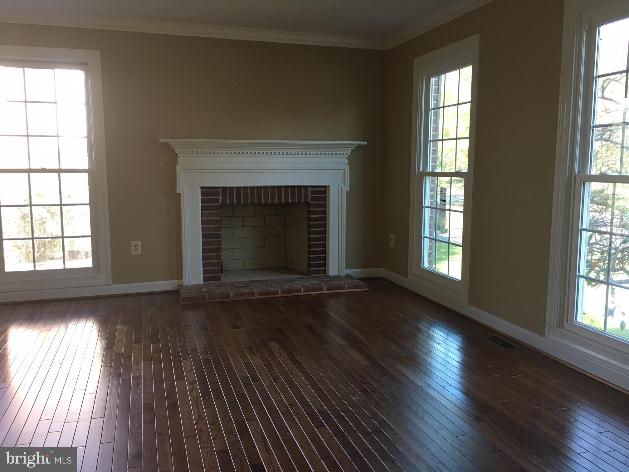 17106 Campbell Farm Road Poolesville, MD 20837 - Photo 7 of 30 an empty room with wooden floor fireplace and windows