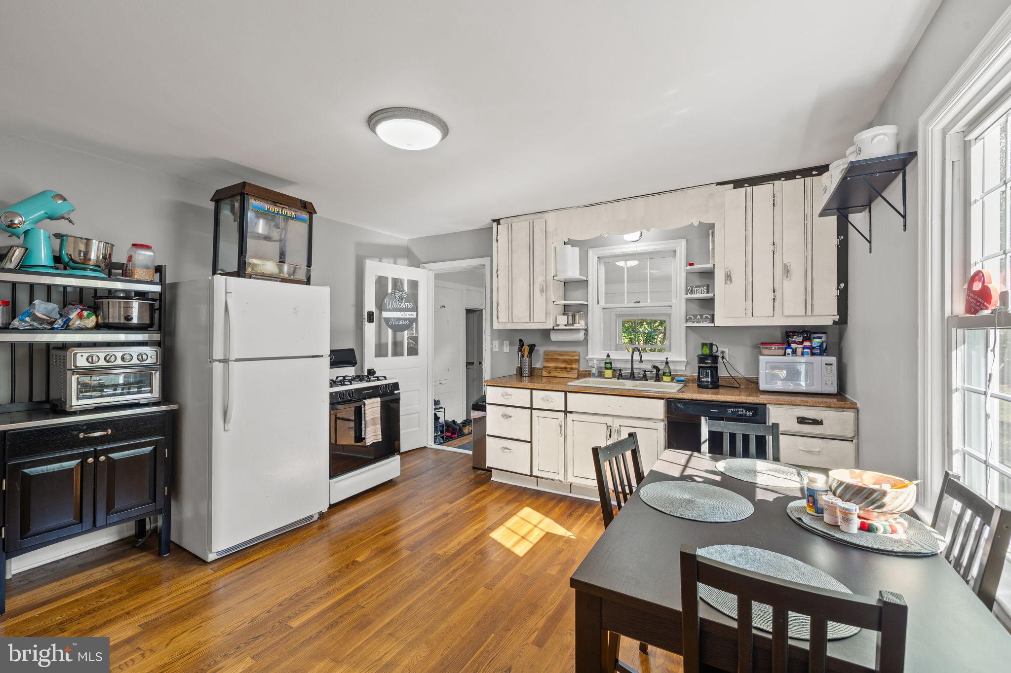 4440 Dumfries Road Catlett, VA 20119 - Photo 6 of 38 a kitchen with stainless steel appliances granite countertop a refrigerator a stove a sink dishwasher and a dining table with wooden floor