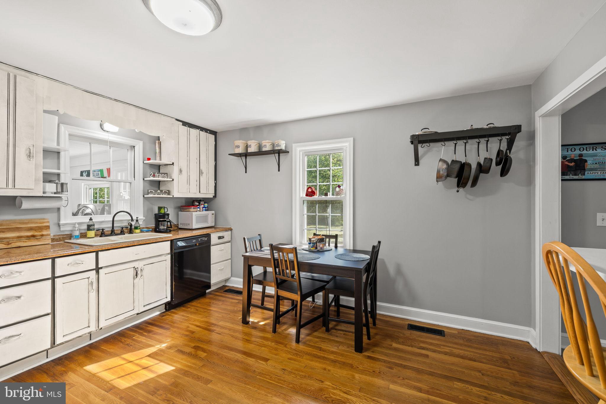 4440 Dumfries Road Catlett, VA 20119 - Photo 7 of 38 a kitchen with granite countertop a dining table chairs and white cabinets